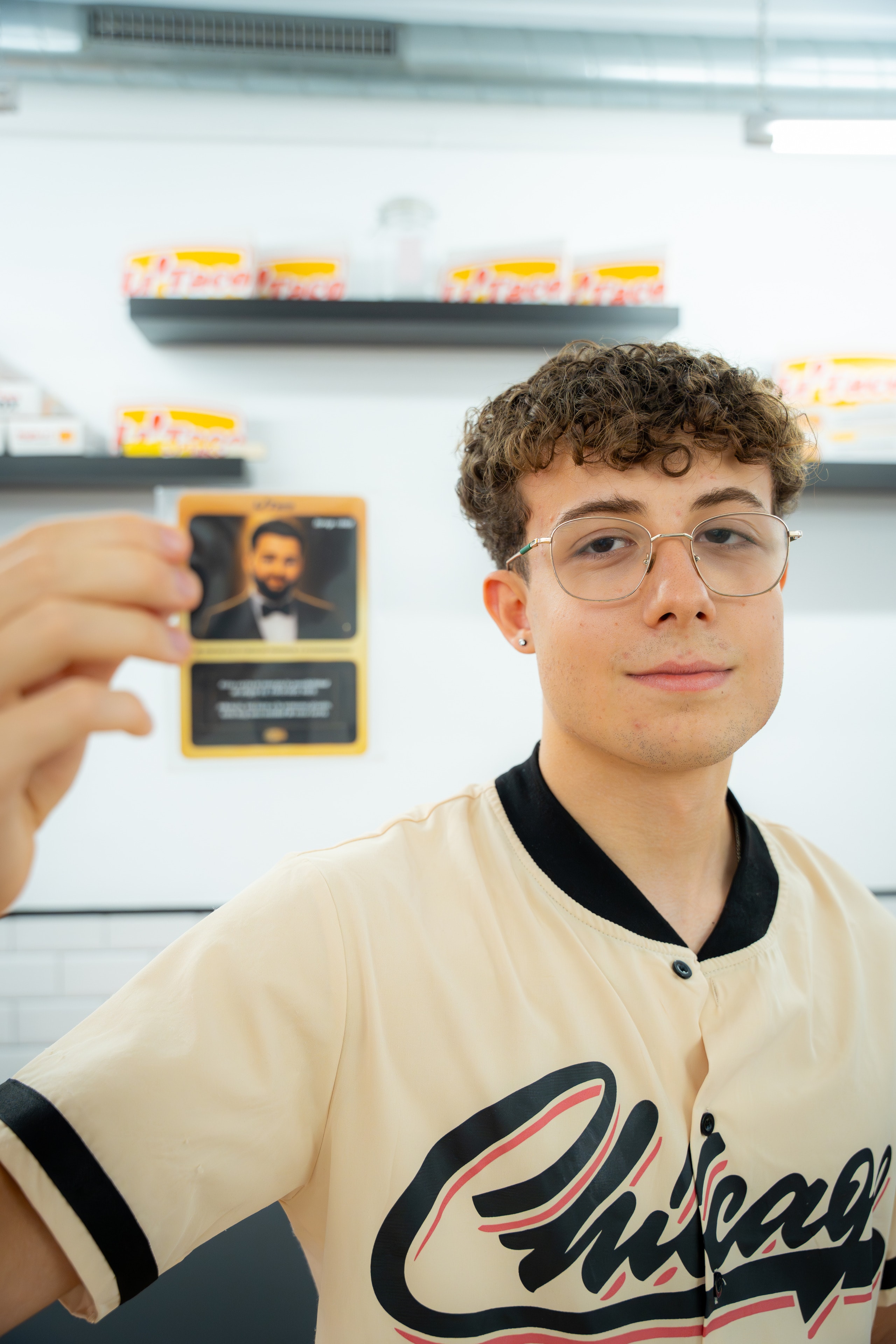 Un chico con gafas enseña su cromo del Drop 001 a la cámara