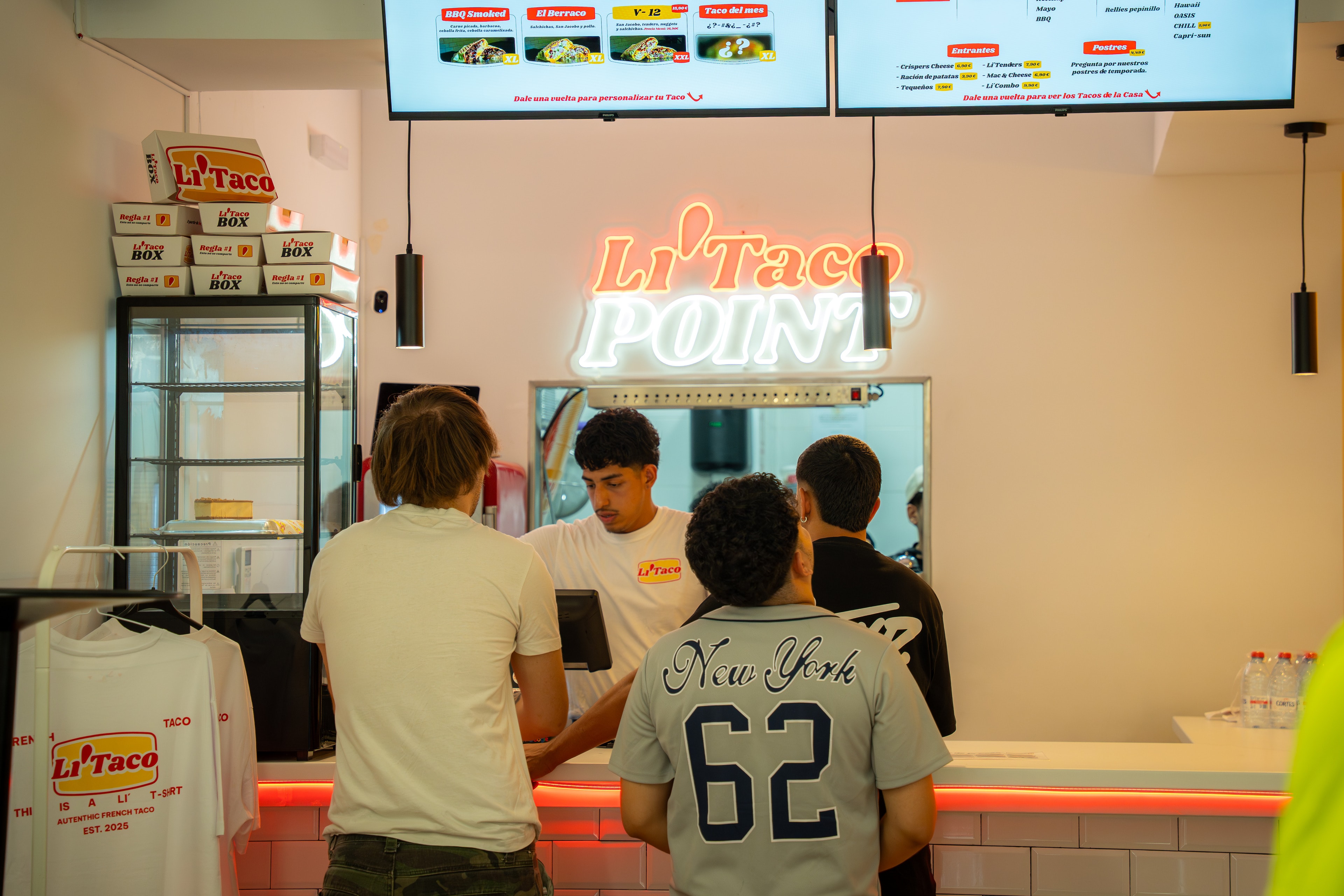 Tres clientes esperan en el mostrador mientras un empleado atiende
